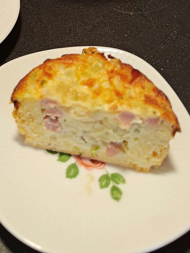 Ein Stück Zwiebelkuchen auf einem Teller mit Blumenmuster